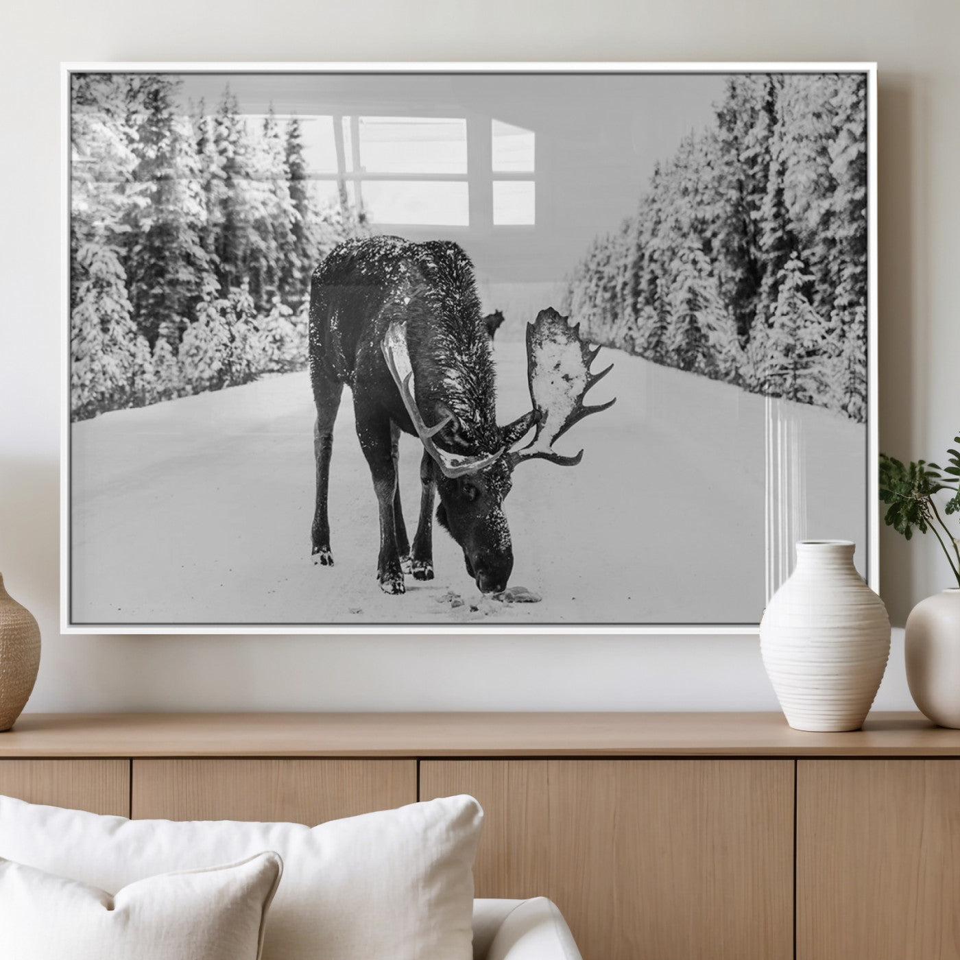 A majestic moose grazing in the snow-covered wilderness, surrounded by snow-covered trees, creating a peaceful winter scene.