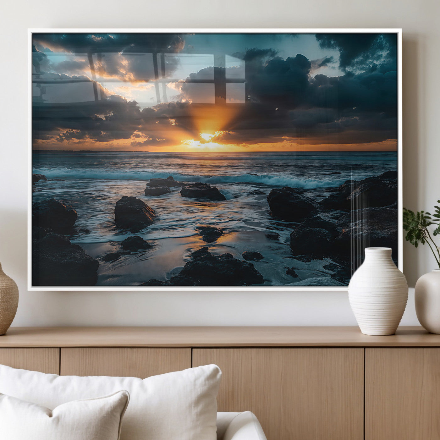 An awe-inspiring sunset over the ocean with rays of light piercing through dramatic clouds, creating a beautiful seascape with rocks in the foreground.