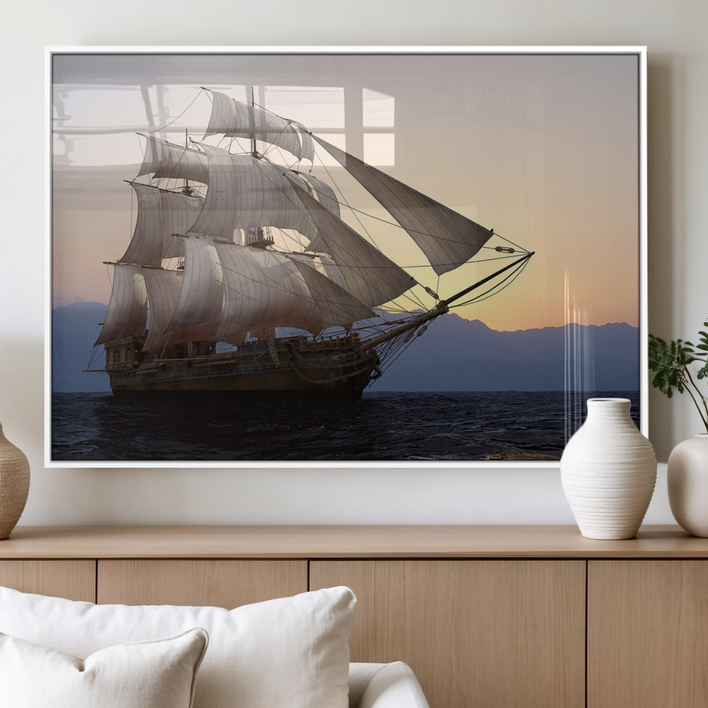 Majestic tall ship with full sails gliding across the ocean at sunset, with mountain silhouettes in the background – Wall Art Canvas Print.
