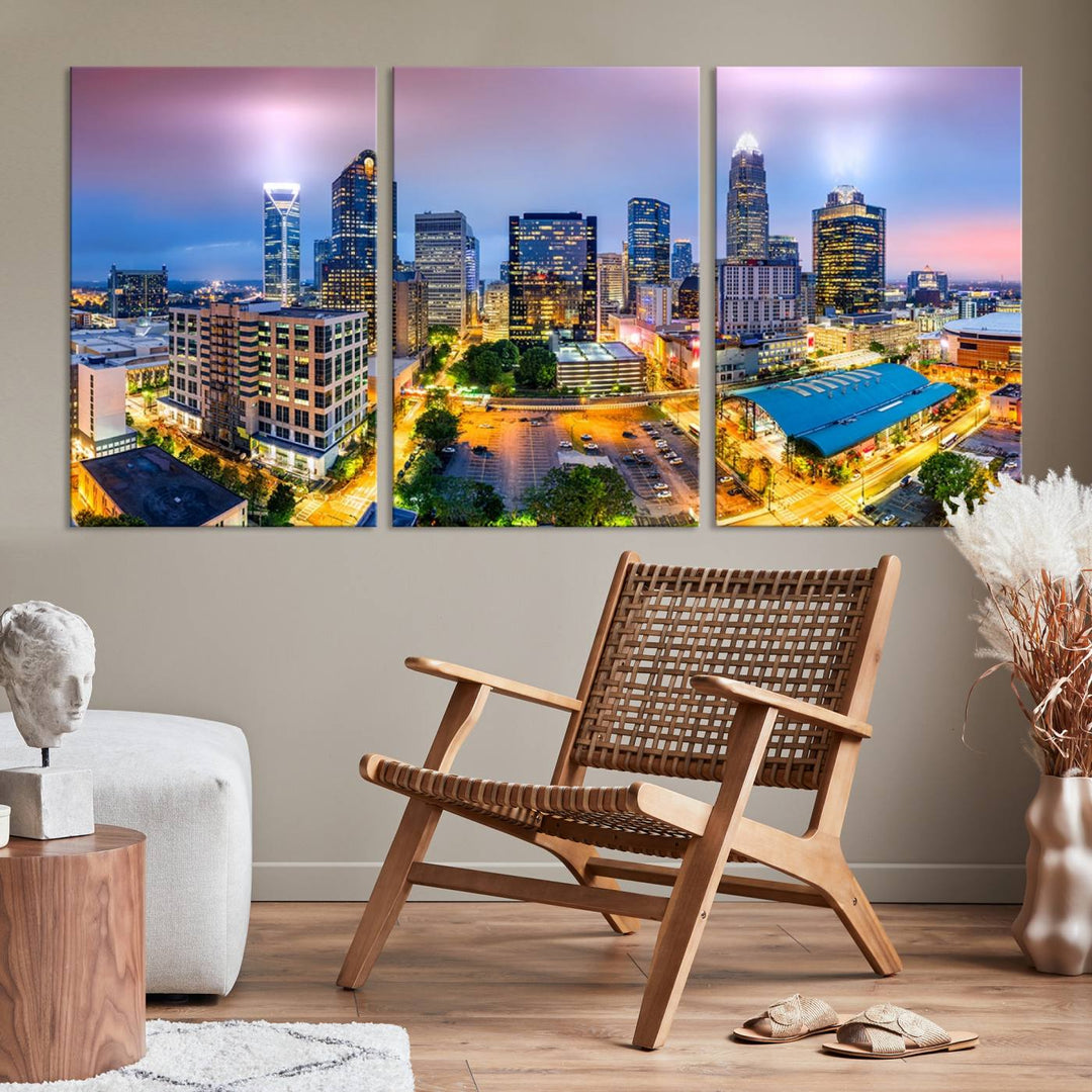 The living room features three large pieces of the *Charlotte City Lights Sunset Purple Skyline Cityscape View Wall Art Canvas Print*. Crafted on gallery-wrapped, museum-quality canvas with UV-protective coating, they grace the wall and add an artistic flair to the space.