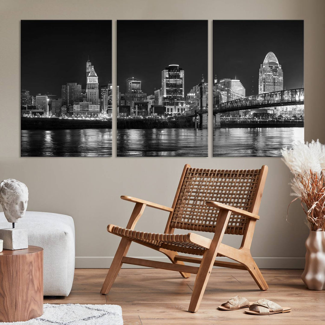 The Cincinnati City Lights Skyline Black and White Wall Art Cityscape Canvas Print elegantly adorns a modern living room. This museum-quality canvas triptych of a city skyline is enhanced by hand-assembled frames for added finesse, and you can enjoy free shipping on this stunning home addition.