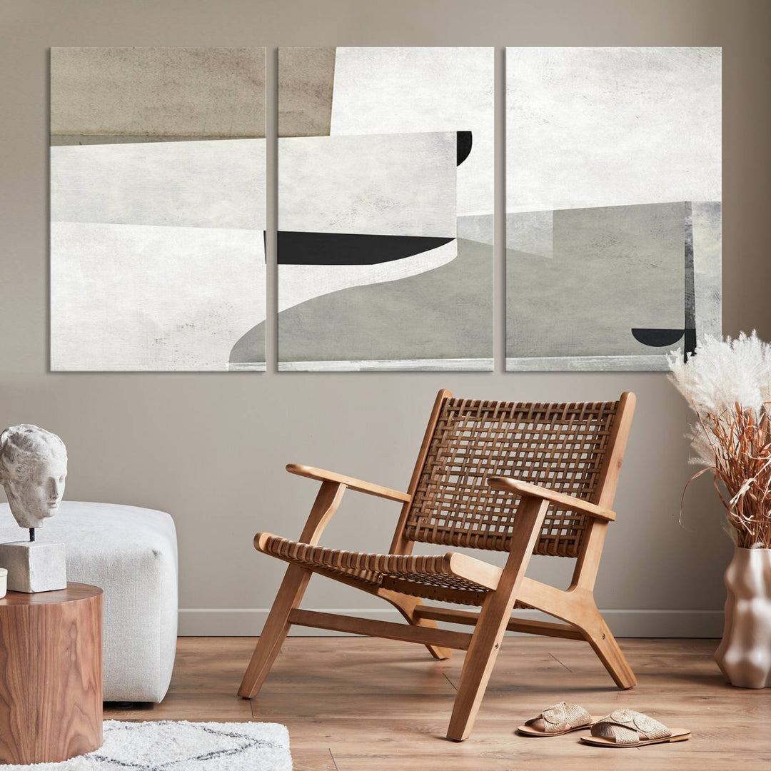 The Brown Gray Figures Abstract Wall Art Canvas Print is displayed as a triptych on a dark wall. The piece is gallery wrapped, offering a seamless finish and enhanced durability due to its UV-protective coating.