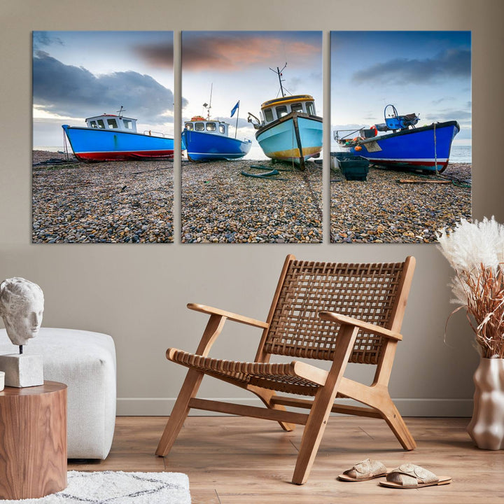 The "Big Boats On The Beach Wall Art Canvas Print" is a stunning piece featuring three museum-quality panels depicting fishing boats on a pebbled shore. Ready to hang and featuring UV-protective coating, it serves as an elegant addition to your home décor.