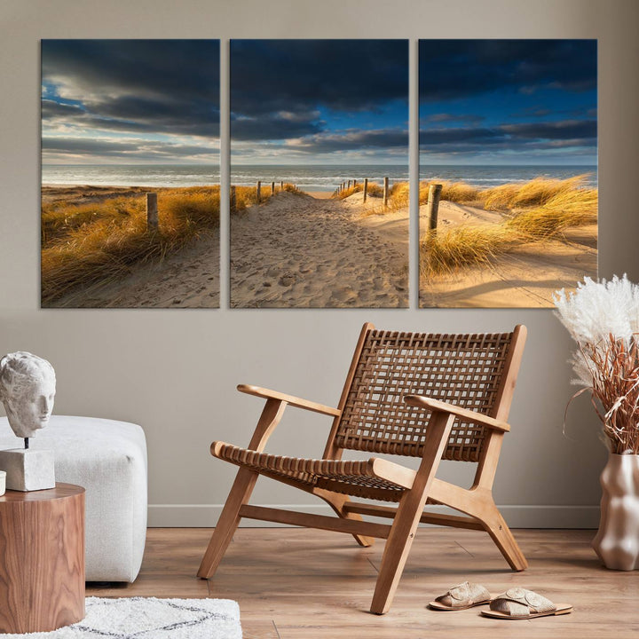 The Ocean Beach Dark Clouds Wall Art Canvas Print is a breathtaking triptych depicting a sandy beach path with tall grasses under an intense cloudy sky. It is crafted on museum-quality canvas with UV protection.