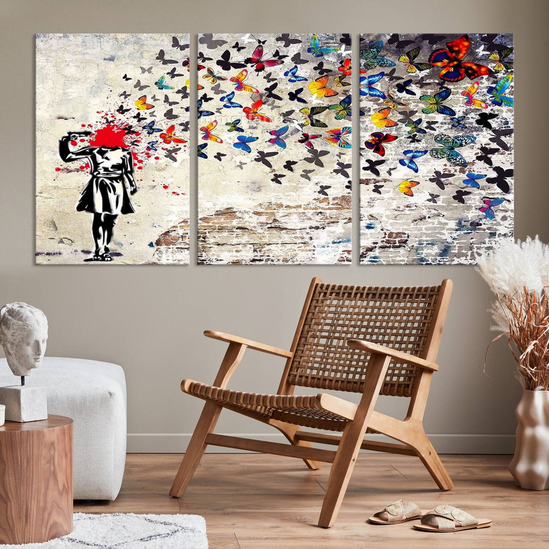 The Banksy Art Butterfly Girl Explosion Canvas showcases a dynamic figure with butterflies bursting from their head, set against a textured wall background. This vibrant urban graffiti piece is perfect for modern interiors and comes ready to hang.