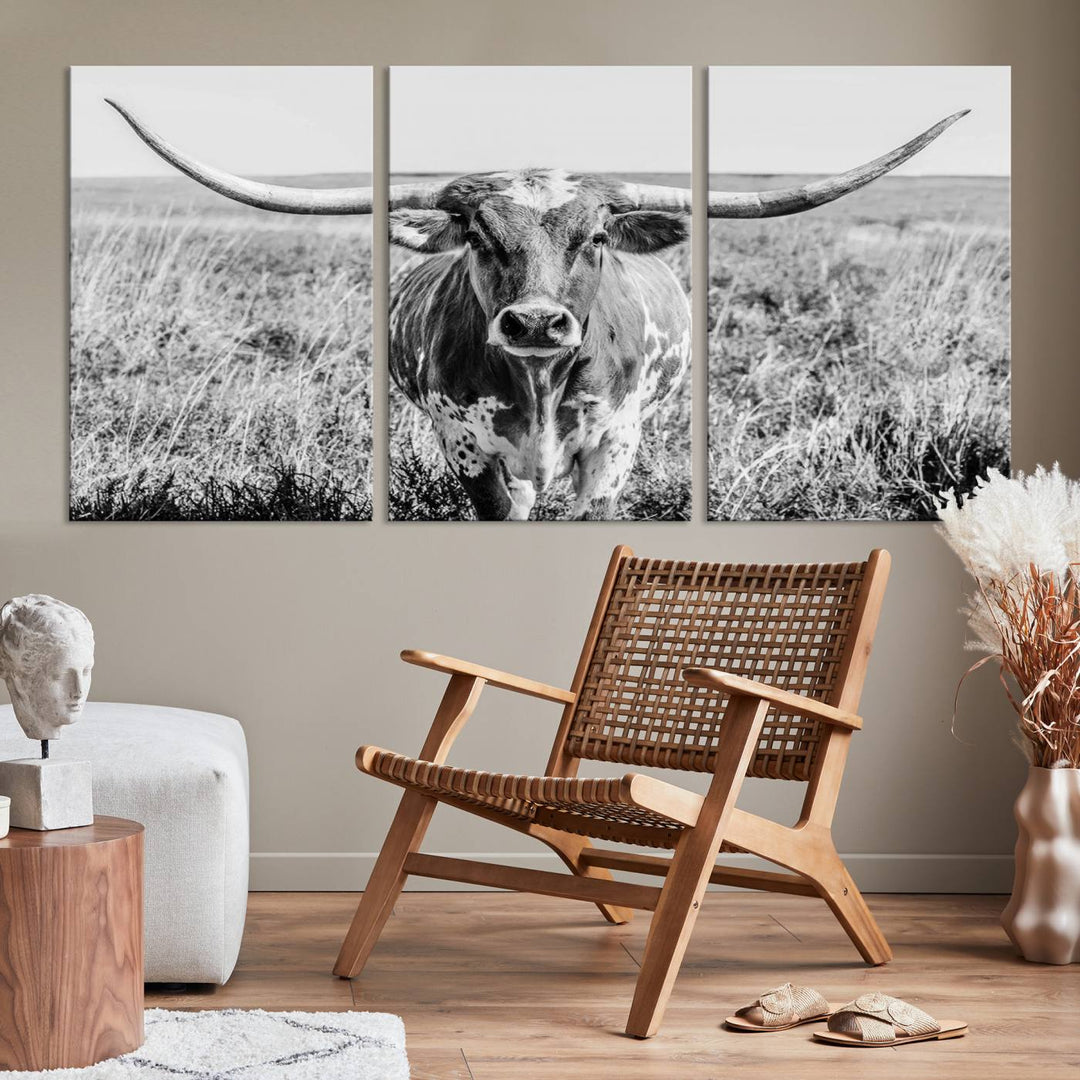 The Texas Cow Longhorn Wall Art Canvas Print is a black and white triptych depicting a cow in a field. It is crafted with museum-quality canvas and features a UV-protective coating.