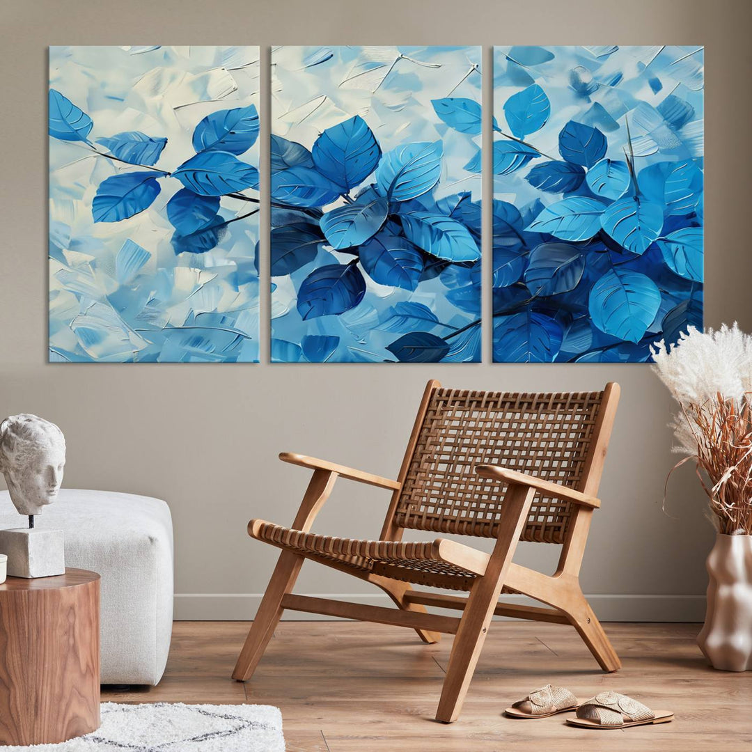 The contemporary living room is highlighted by the Abstract Blue Leaf Wall Art Canvas Print on the wall. The hand-assembled framed art enhances the room's vibrant decor, crafting a gallery-worthy ambience.