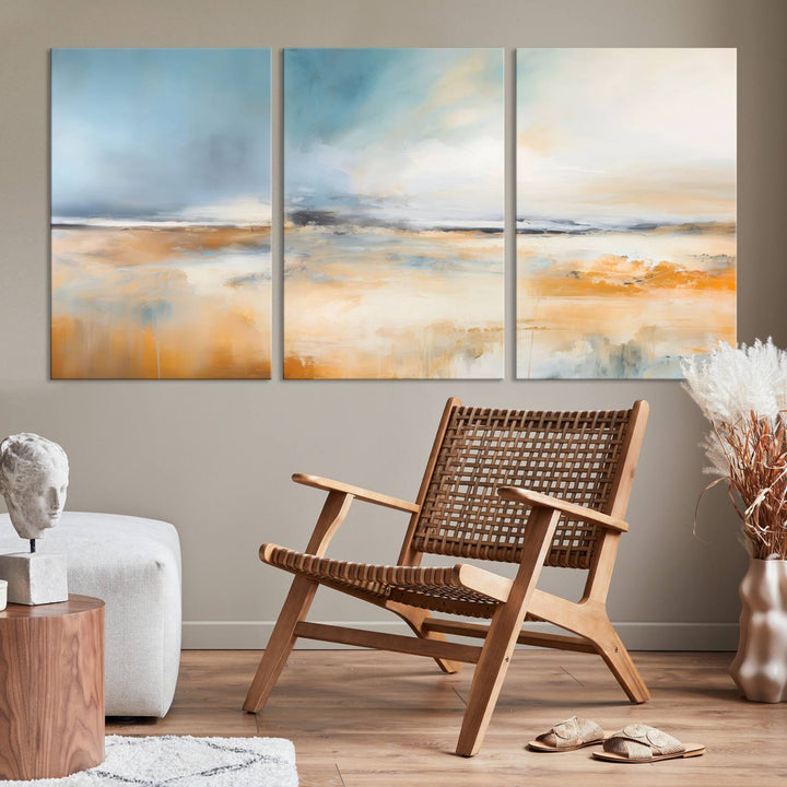 The Abstract Landscape Wall Art Canvas Print, featuring warm tones of orange and blue, is displayed on a dark wall.