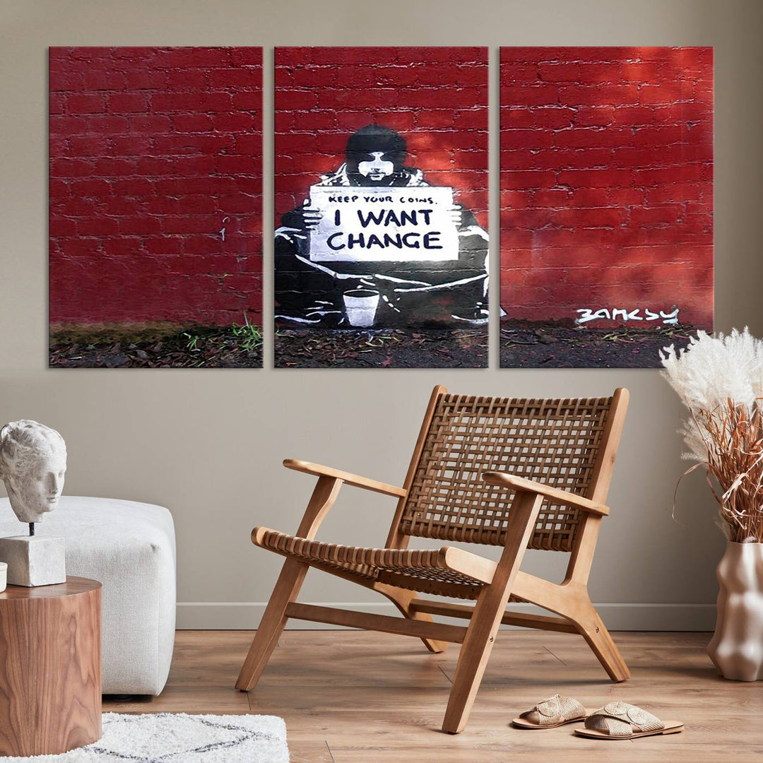 The living room showcases a triptych of stencil artwork on museum-quality canvas, featuring the Banksy I Want Change Graffiti Abstract Wall Art Canvas Print. This captivating piece depicts a person holding a sign that says "I want change" and is finished with a UV-protective coating to ensure long-lasting beauty.