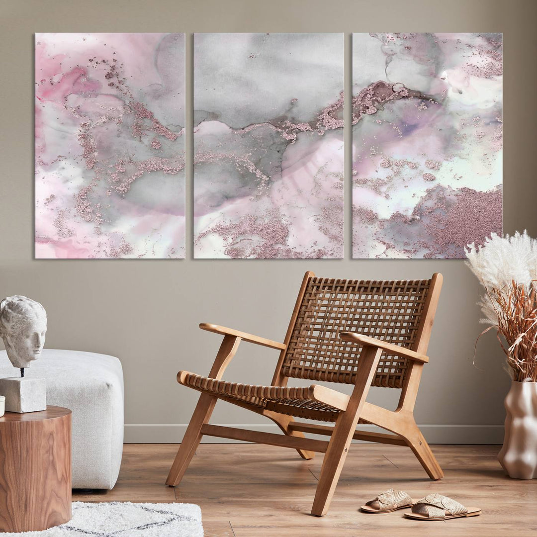 The Rose Marble Abstract Wall Art Canvas Print is a stunning triptych that showcases pink and gray tones, elegantly presented on a dark wall.