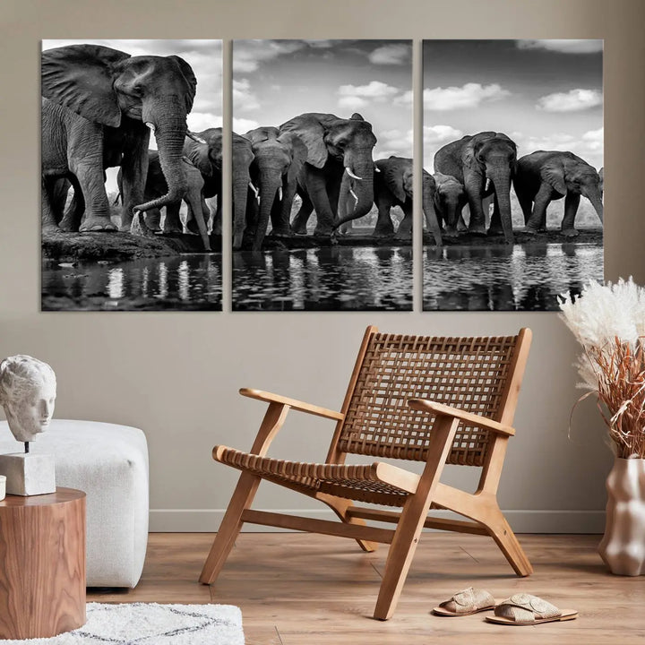 A stunning "Wall Art Animal Canvas Print" featuring a black and white photo of a herd of elephants drinking water is elegantly displayed, gallery wrapped on museum-quality canvas.