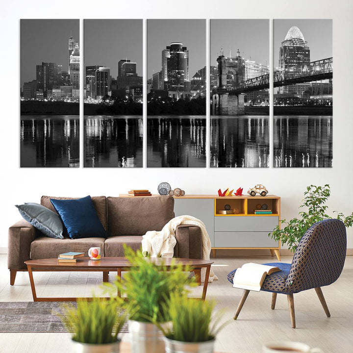 The wall showcases a ready-to-hang triptych of the Cincinnati City Lights Skyline in black and white, printed on museum-quality canvas.