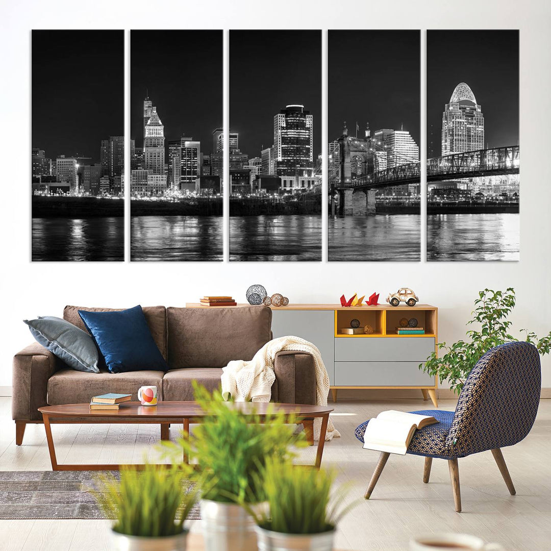 The Cincinnati City Lights Skyline Black and White Wall Art Cityscape Canvas Print elegantly adorns a modern living room. This museum-quality canvas triptych of a city skyline is enhanced by hand-assembled frames for added finesse, and you can enjoy free shipping on this stunning home addition.