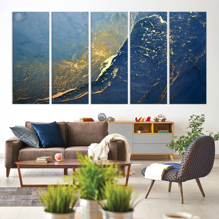 The Navy Blue Yellow Twinkle Wall Art Canvas Print, featuring an abstract design in gold and blue, enhances a modern living room as it adorns a white wall with its gallery-wrapped, museum-quality canvases for an exquisite touch.