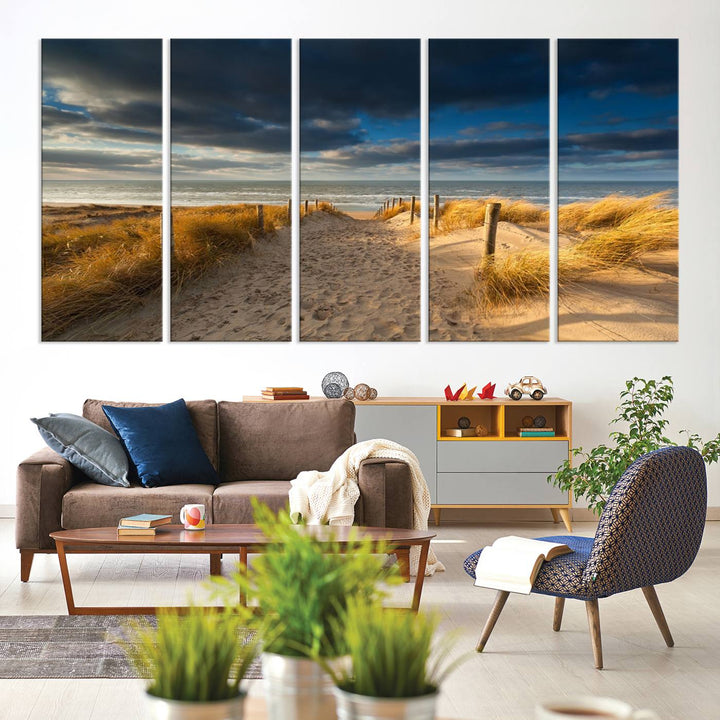 The Ocean Beach Dark Clouds Wall Art Canvas Print is a breathtaking triptych depicting a sandy beach path with tall grasses under an intense cloudy sky. It is crafted on museum-quality canvas with UV protection.