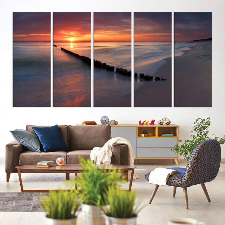 In a modern living room, the Sunset Beach Wall Art Canvas Print is displayed above. This triptych, printed on museum-quality canvas with a UV-protective coating, ensures lasting brilliance. It's ready to hang and brings an elegant touch to your space.