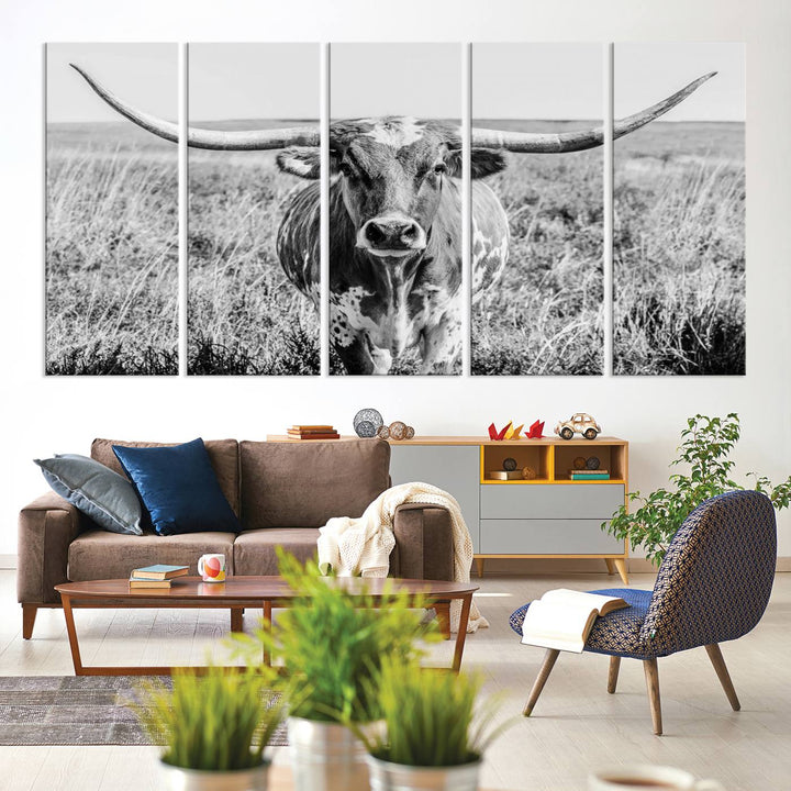 The Texas Cow Longhorn Wall Art Canvas Print is a black and white triptych depicting a cow in a field. It is crafted with museum-quality canvas and features a UV-protective coating.