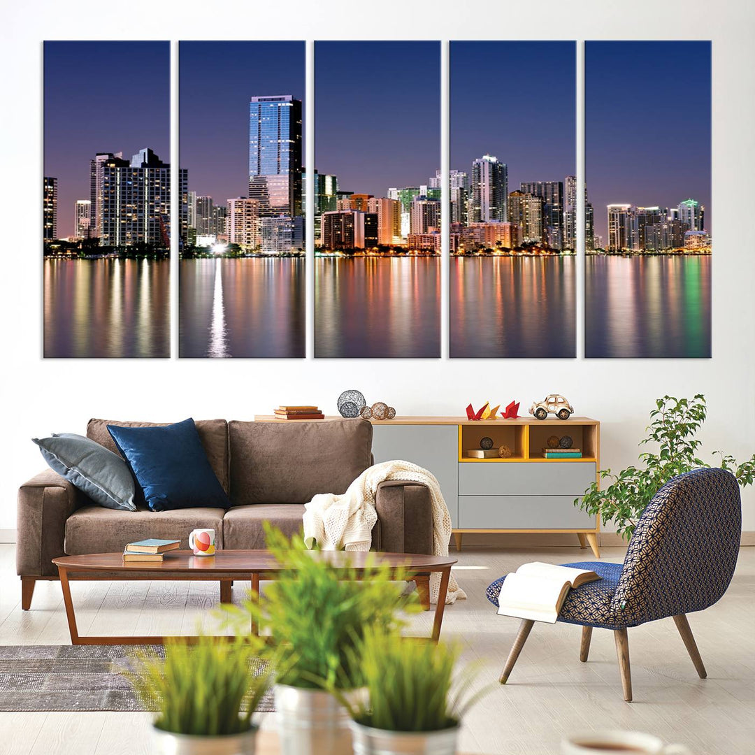 The Miami Skyline Canvas Wall Art Print showcases a vibrant night cityscape and beautifully captures the dazzling colorful lights reflecting on the water. This ready-to-hang triptych adorns the wall, creating a stunning visual centerpiece.