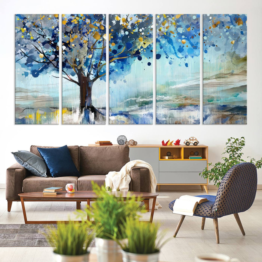 A modern living room features a three-panel Watercolor Style Abstract Tree Printing Wall Art Canvas in vibrant blue and yellow, crafted on museum-quality material.