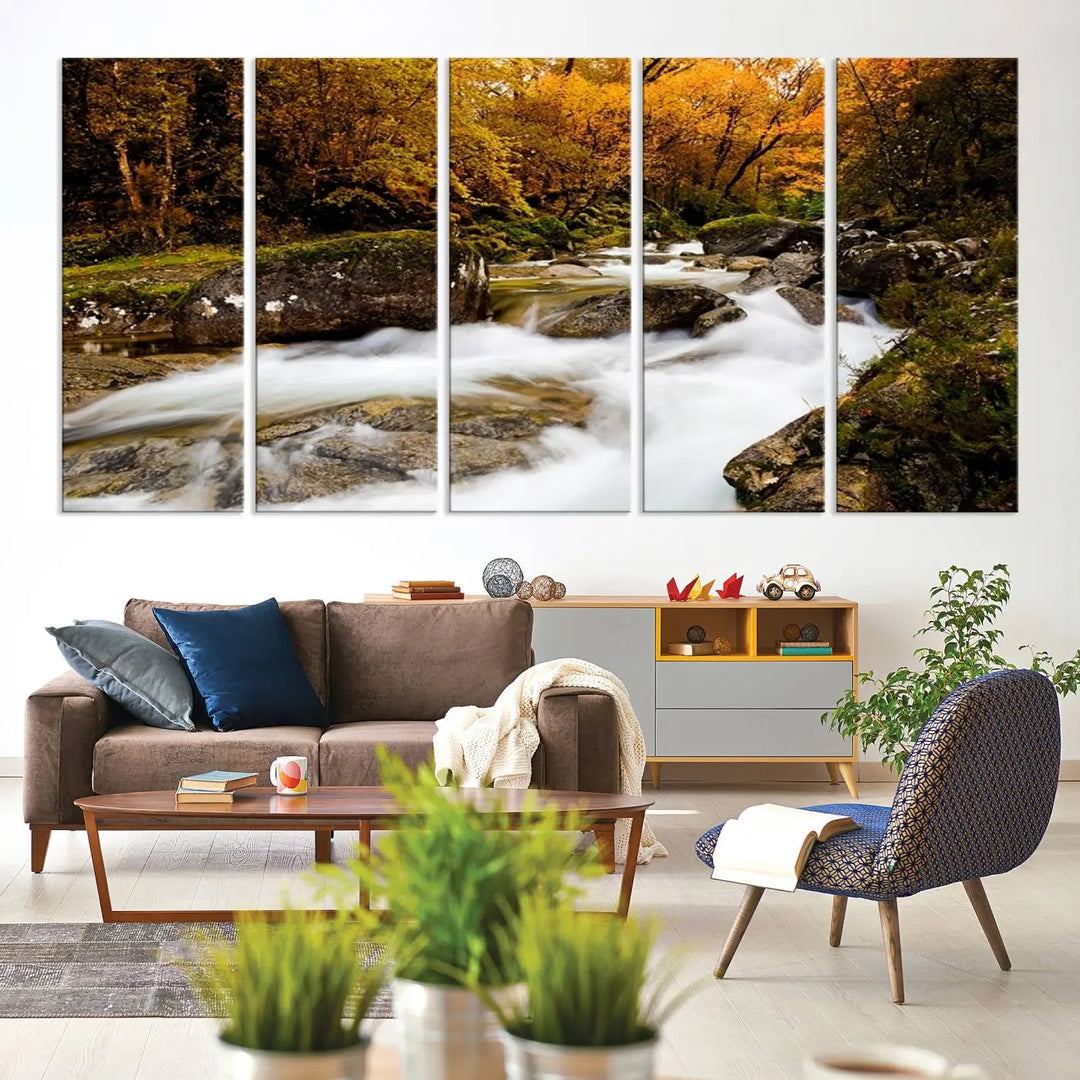 The living room is adorned with the "Wall Art Waterfall Canvas Print River in Forest in Autumn," a triptych on museum-quality canvas showcasing a flowing river surrounded by autumn trees. This ready-to-hang artwork features a UV-protective coating to ensure enduring vibrancy.