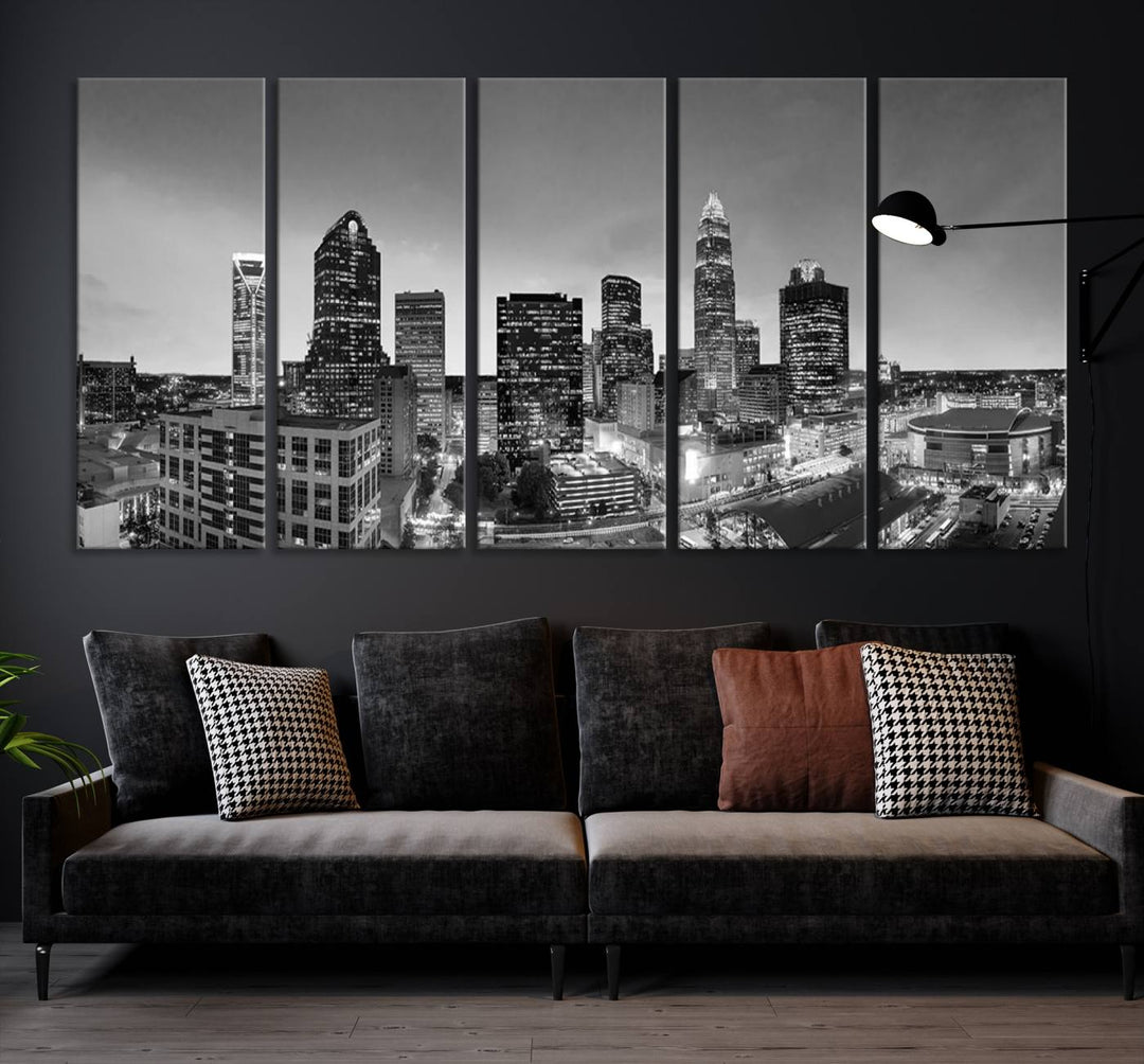 The "Charlotte City Cloudy Skyline Black and White Wall Art Cityscape Canvas Print" hangs on a dark wall, showcasing its UV-protective properties for enduring beauty.