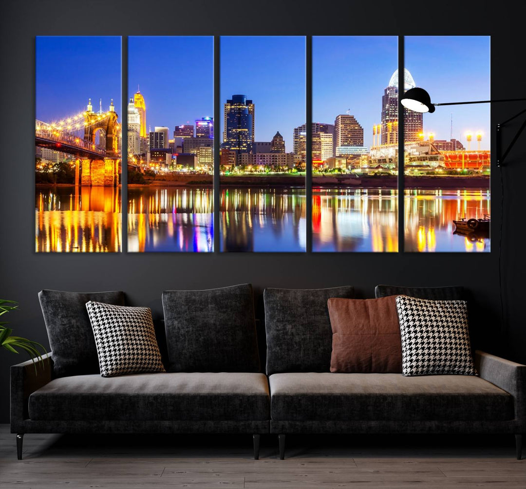 The "Cincinnati City Lights Night Skyline Cityscape View Wall Art Canvas Print" is a gallery-wrapped, museum-quality canvas illustrating a lit-up bridge and skyline at night. Enhanced with a UV-protective coating, this piece ensures lasting vibrancy.