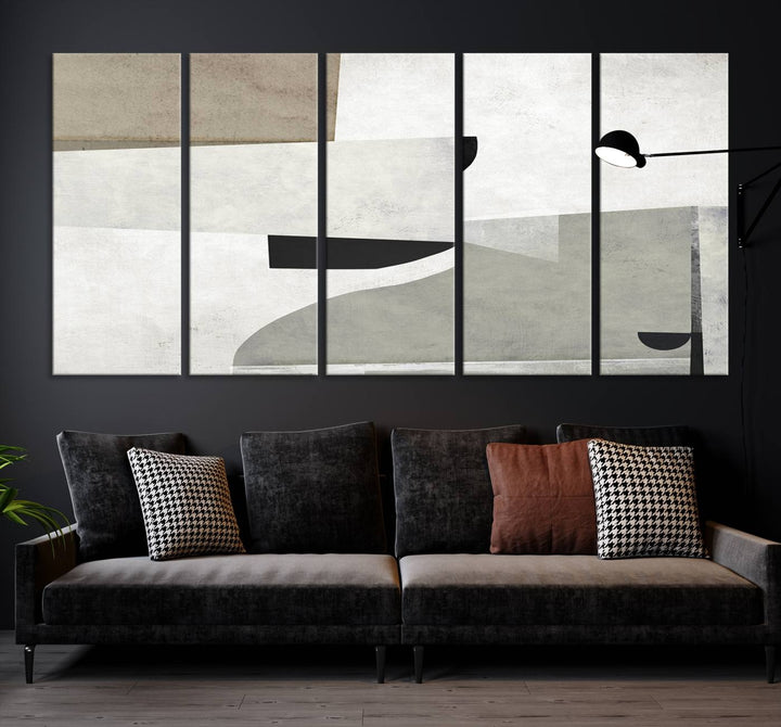 The Brown Gray Figures Abstract Wall Art Canvas Print is displayed as a triptych on a dark wall. The piece is gallery wrapped, offering a seamless finish and enhanced durability due to its UV-protective coating.