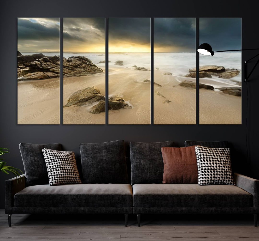 A gallery-wrapped, three-panel artwork titled "Rocks and Waves Wall Art Canvas Print" depicts a rocky beach at sunset. Each canvas showcases museum-quality craftsmanship and a UV-protective coating to maintain its vibrant colors.