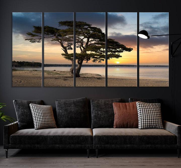 The room showcases the Coastal Sunset Wall Art Canvas Print, a triptych elegantly displayed on museum-quality polycotton canvas, depicting a serene beach sunset with a tree.