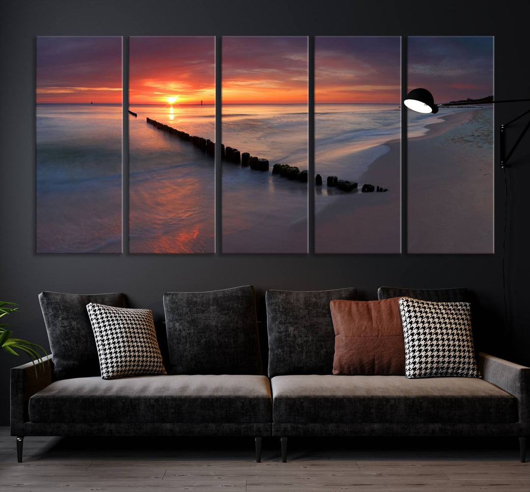 In a modern living room, the Sunset Beach Wall Art Canvas Print is displayed above. This triptych, printed on museum-quality canvas with a UV-protective coating, ensures lasting brilliance. It's ready to hang and brings an elegant touch to your space.