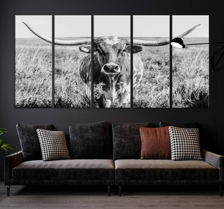 The Texas Cow Longhorn Wall Art Canvas Print is a black and white triptych depicting a cow in a field. It is crafted with museum-quality canvas and features a UV-protective coating.