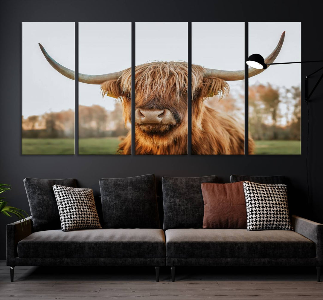 A Highland Cow Animal Scottish Cattle Art Print Farmhouse Wall Art Canvas Print hangs in the living room, adding a touch of rustic farmhouse decor.