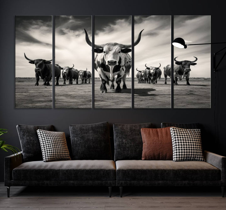 The Black and White Longhorn Cattle Wall Art, featuring a three-panel display of cowboy Western longhorns walking toward the viewer, enhances your space with its striking presence, adding a touch of Western decor.