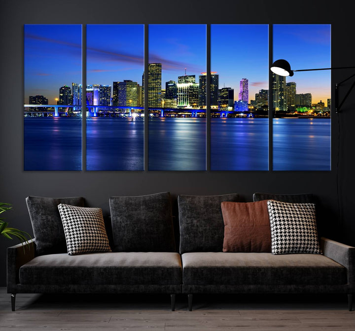 The modern living room showcases a striking Miami Blue Night Wall Art canvas print on the wall. The artwork is gallery wrapped on museum-quality canvas, ensuring durability and elegance.