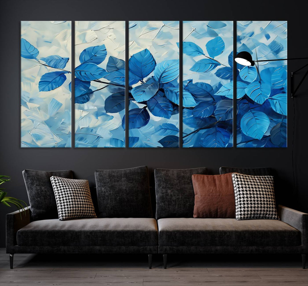 The contemporary living room is highlighted by the Abstract Blue Leaf Wall Art Canvas Print on the wall. The hand-assembled framed art enhances the room's vibrant decor, crafting a gallery-worthy ambience.