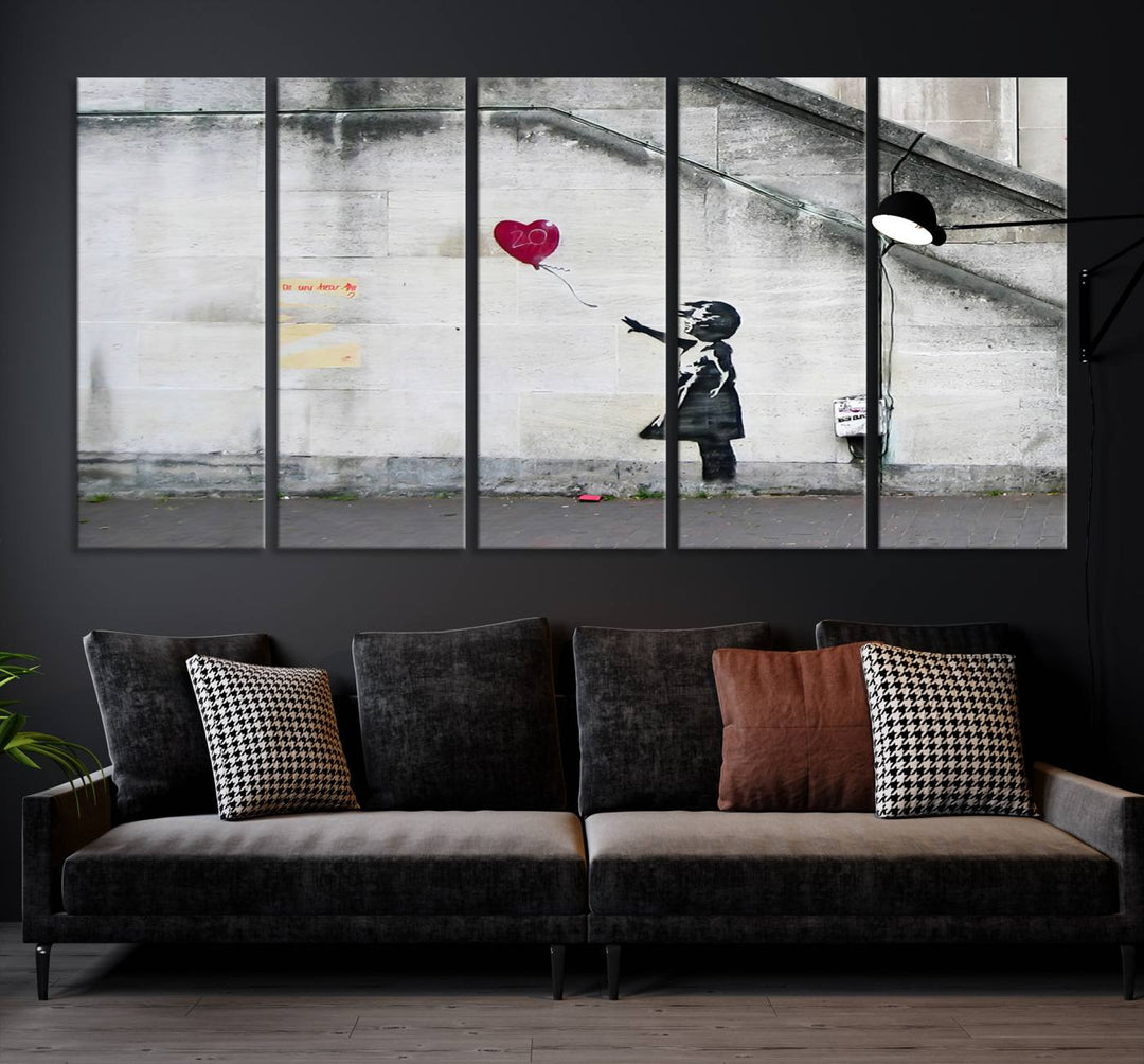 The "Girl with a Balloon Banksy Street Graffiti Art Canvas Print" is a gallery-quality wall art piece that features an image of a girl releasing a heart-shaped balloon. Handmade in the USA, this canvas artwork brings charm and emotion to any room.