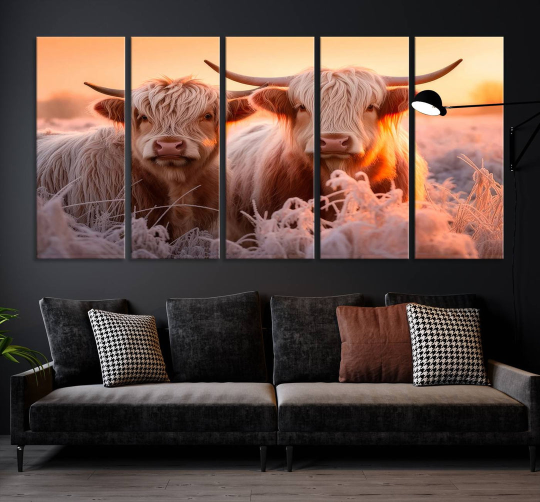 The "Highland Cows at Sunrise Wall Art Canvas Set" beautifully captures a serene and rustic farmhouse aesthetic, portraying two Highland cows in a frosty landscape at sunrise.