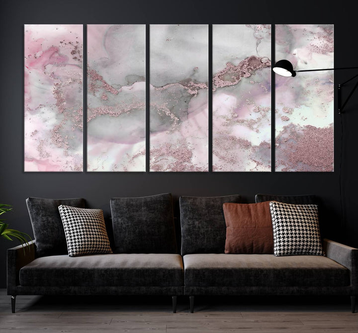 The Rose Marble Abstract Wall Art Canvas Print is a stunning triptych that showcases pink and gray tones, elegantly presented on a dark wall.