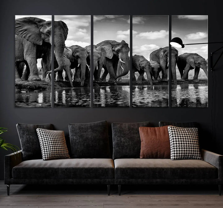 A stunning "Wall Art Animal Canvas Print" featuring a black and white photo of a herd of elephants drinking water is elegantly displayed, gallery wrapped on museum-quality canvas.