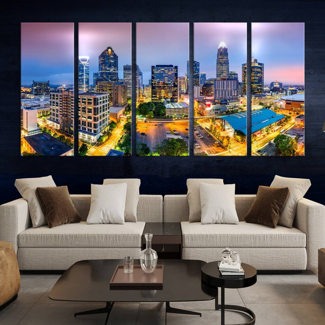 The living room features three large pieces of the *Charlotte City Lights Sunset Purple Skyline Cityscape View Wall Art Canvas Print*. Crafted on gallery-wrapped, museum-quality canvas with UV-protective coating, they grace the wall and add an artistic flair to the space.