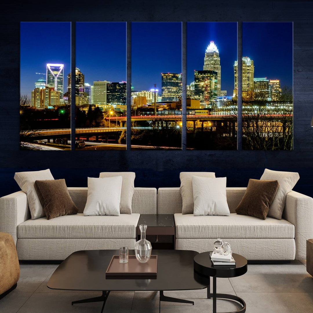 The Charlotte City Lights Night Blue Skyline Cityscape View Wall Art Canvas Print, showcasing an illuminated city skyline at night, is printed on museum-quality canvas with a UV-protective coating. Enhance your space with this stunning piece and enjoy free shipping with your purchase.