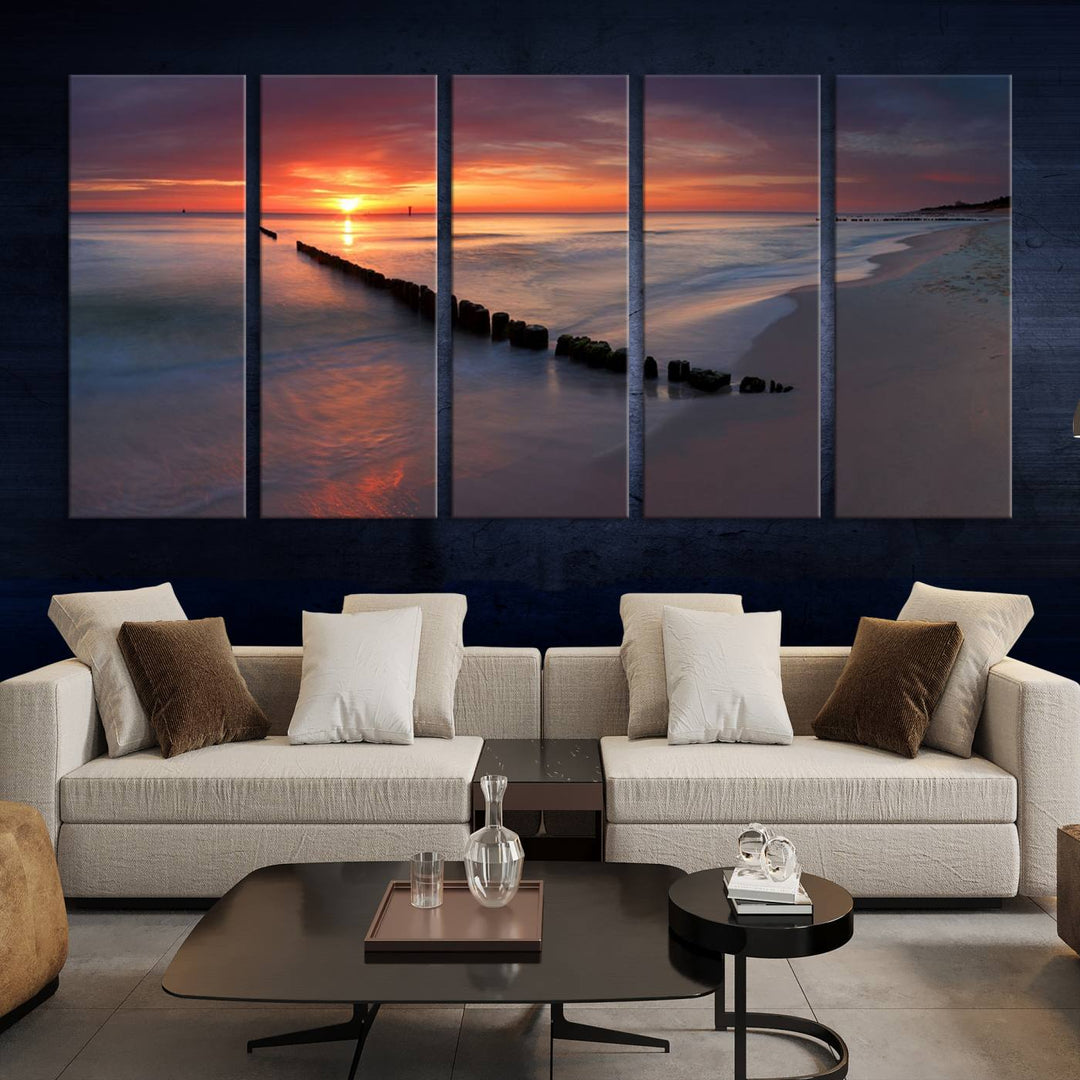 In a modern living room, the Sunset Beach Wall Art Canvas Print is displayed above. This triptych, printed on museum-quality canvas with a UV-protective coating, ensures lasting brilliance. It's ready to hang and brings an elegant touch to your space.