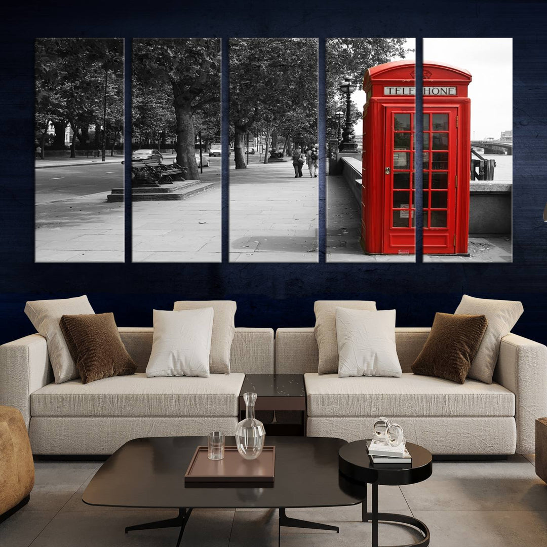 The London Phone Club Wall Art is a stunning piece that showcases a red telephone box set in a black and white street scene on museum-quality canvas. It is gallery wrapped with a UV-protective coating to preserve its vibrant charm.