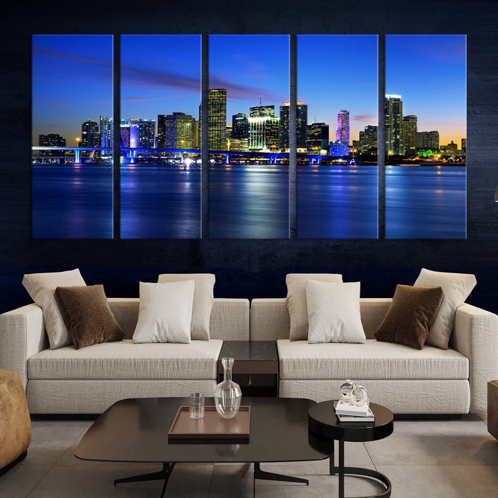 The modern living room showcases a striking Miami Blue Night Wall Art canvas print on the wall. The artwork is gallery wrapped on museum-quality canvas, ensuring durability and elegance.