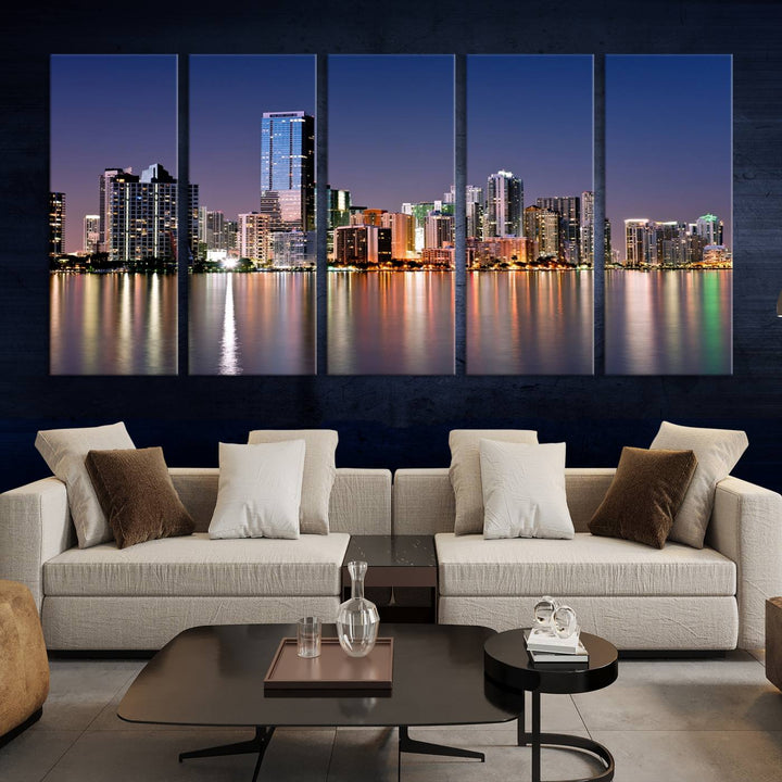 The Miami Skyline Canvas Wall Art Print showcases a vibrant night cityscape and beautifully captures the dazzling colorful lights reflecting on the water. This ready-to-hang triptych adorns the wall, creating a stunning visual centerpiece.