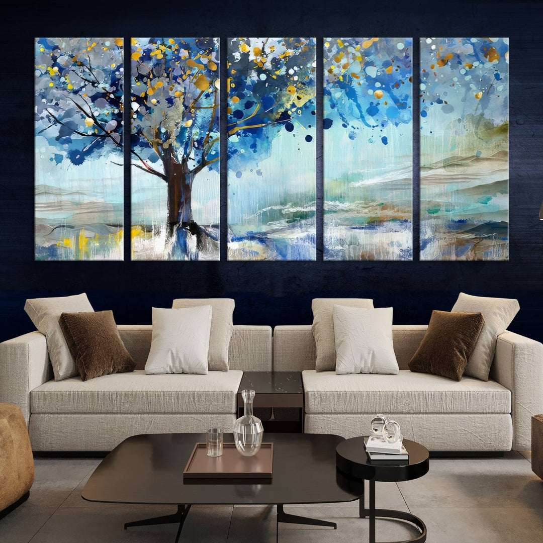 A modern living room features a three-panel Watercolor Style Abstract Tree Printing Wall Art Canvas in vibrant blue and yellow, crafted on museum-quality material.