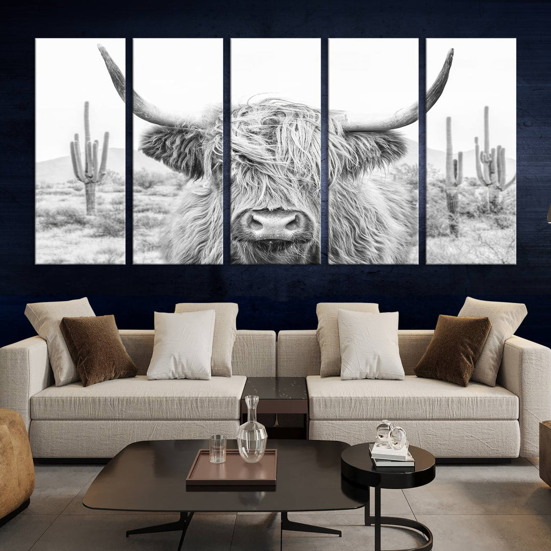 The "Rustic Charm | Cow Longhorn Black White Bighorn Wall Art Canvas Print" is a stunning triptych that showcases a highland cow with long horns set against a desert landscape with cacti in the background. This farmhouse wall art elevates any room into a rustic haven with its gallery-quality canvas.