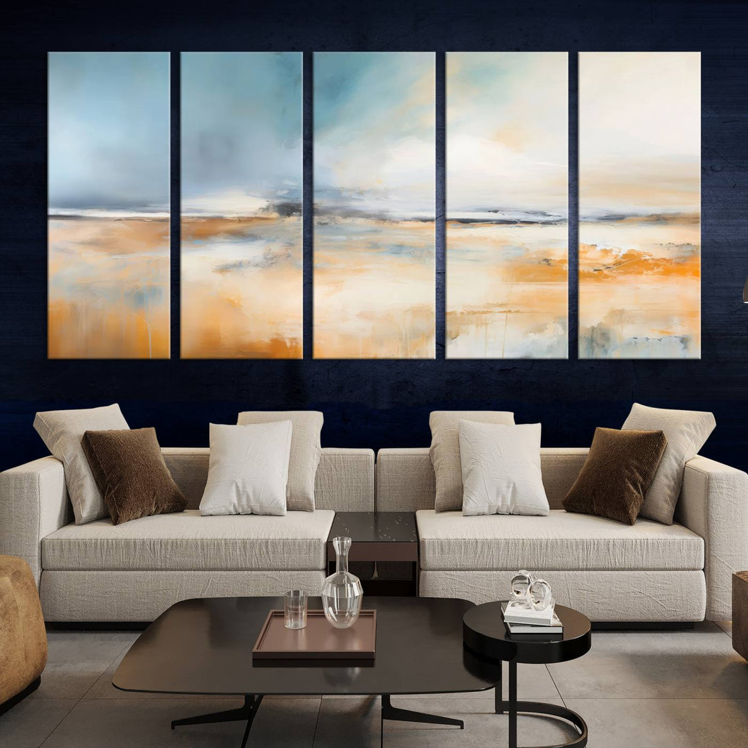 The Abstract Landscape Wall Art Canvas Print, featuring warm tones of orange and blue, is displayed on a dark wall.