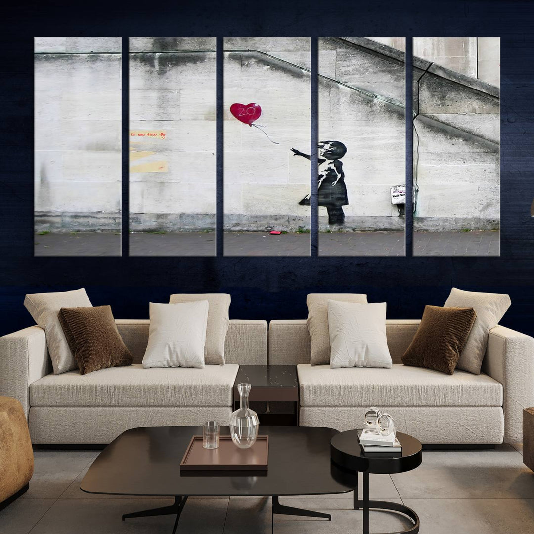 The "Girl with a Balloon Banksy Street Graffiti Art Canvas Print" is a gallery-quality wall art piece that features an image of a girl releasing a heart-shaped balloon. Handmade in the USA, this canvas artwork brings charm and emotion to any room.