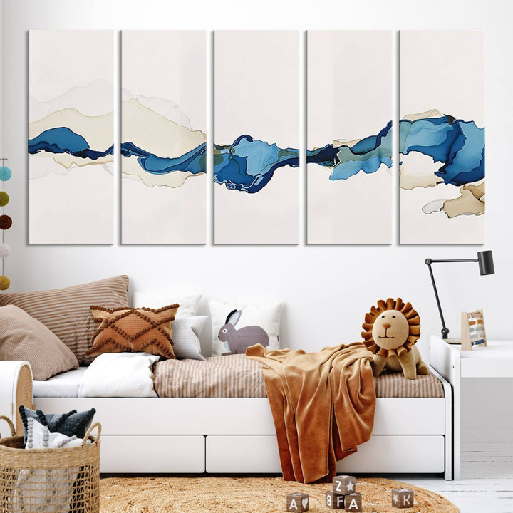 The modern living room showcases a set of three canvas prints with abstract blue art on museum-quality materials.